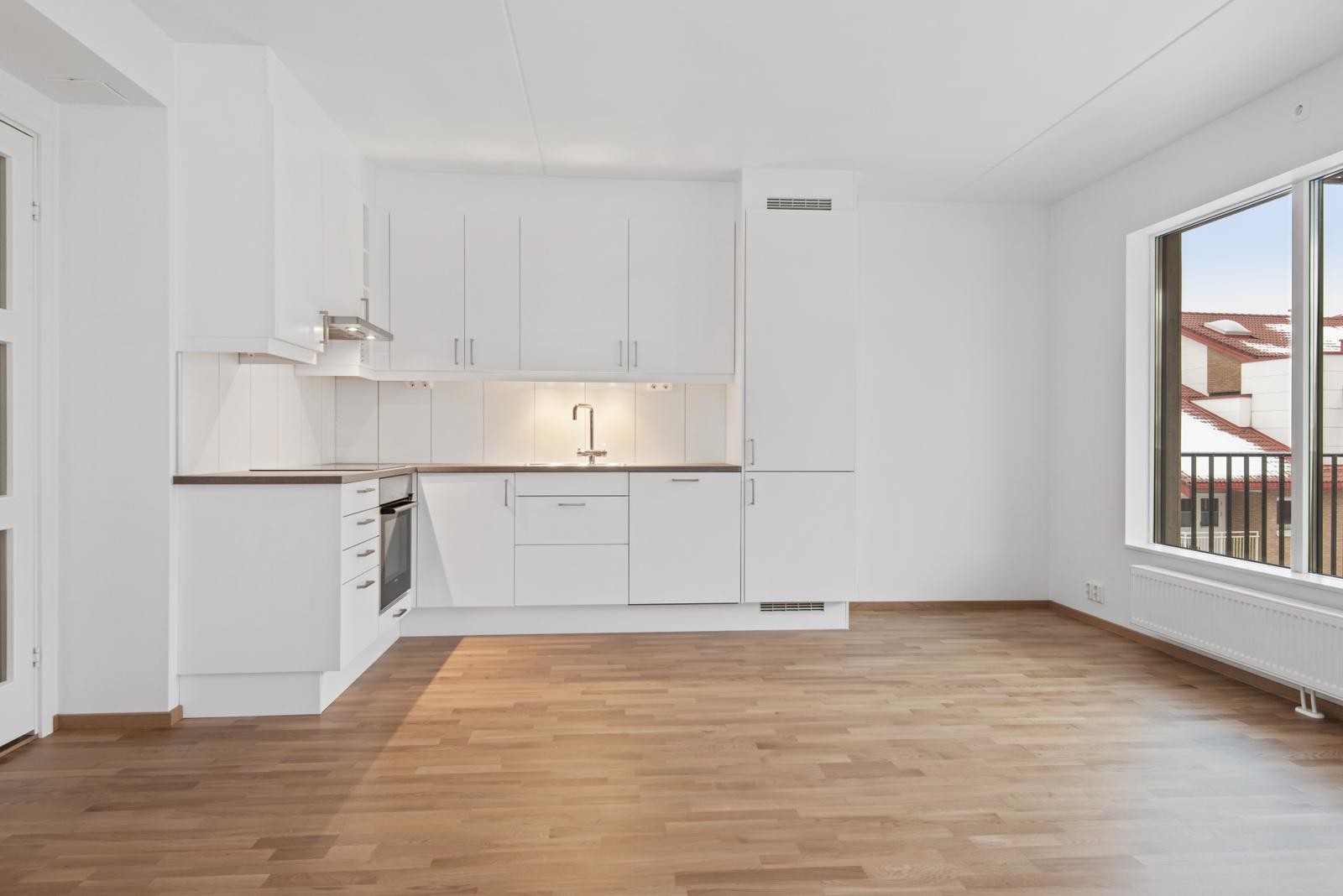 Åpen stue- og kjøkkenløsning. Hvitevarer følger med (komfyr, kombiskap og oppvaskmaskin). Galleribilde
