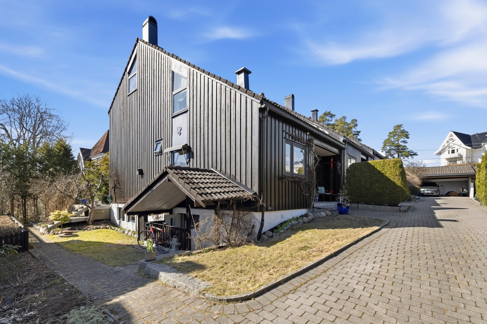 Huset ligger på et hyggelig felt med brostein, gressplen, hekk og frukttrær - og gode naboer passe tett på. Galleribilde