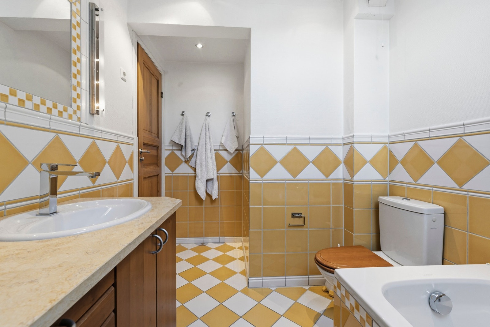 Badet har varmekabel i støp med trinnløs regulator. Vegglimt speil med omrammede fliser og sidemontert belysning over servanten. Alle lys på badet kan dimmes. Galleribilde