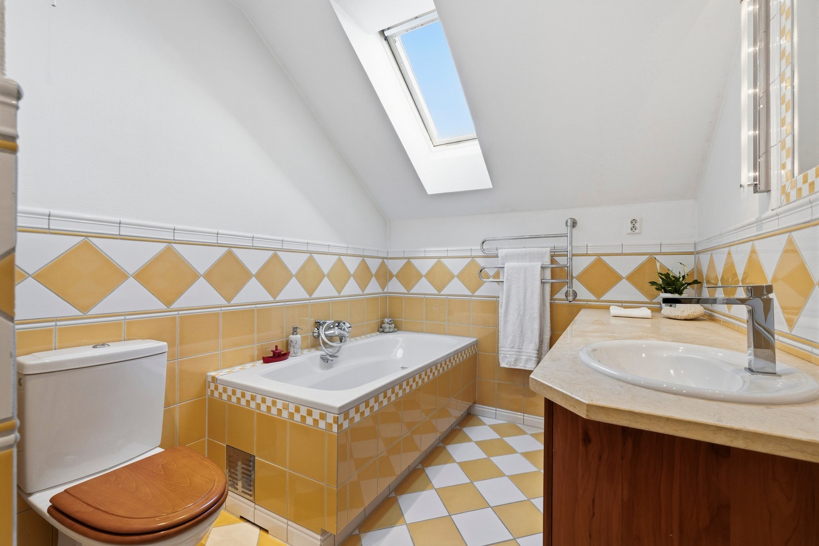 Romslig bad med badekar pusset opp i 2005 etter tegninger fra interiørarkitekt Åse Imset. Baderomsinnredning fra HTH med skuffer i heltre og benkeplate i stein. Galleribilde