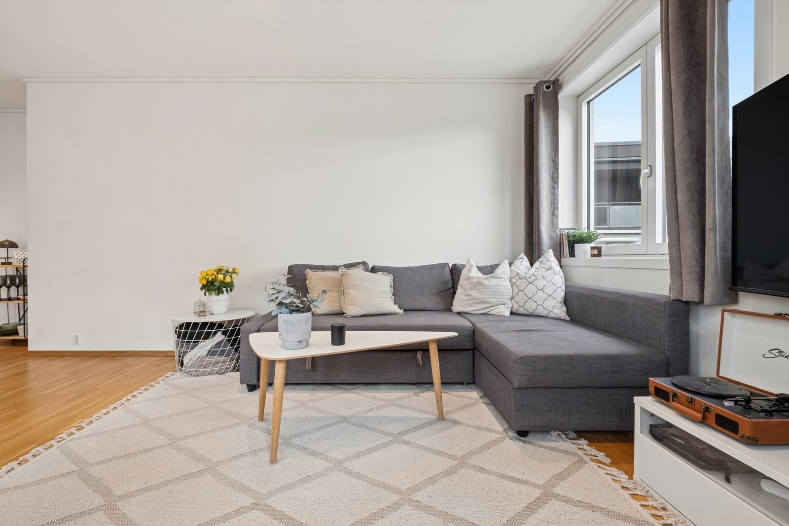 Stuen har god plass til en sofagruppe. Leiligheten oppvarmes med panelovner. Galleribilde