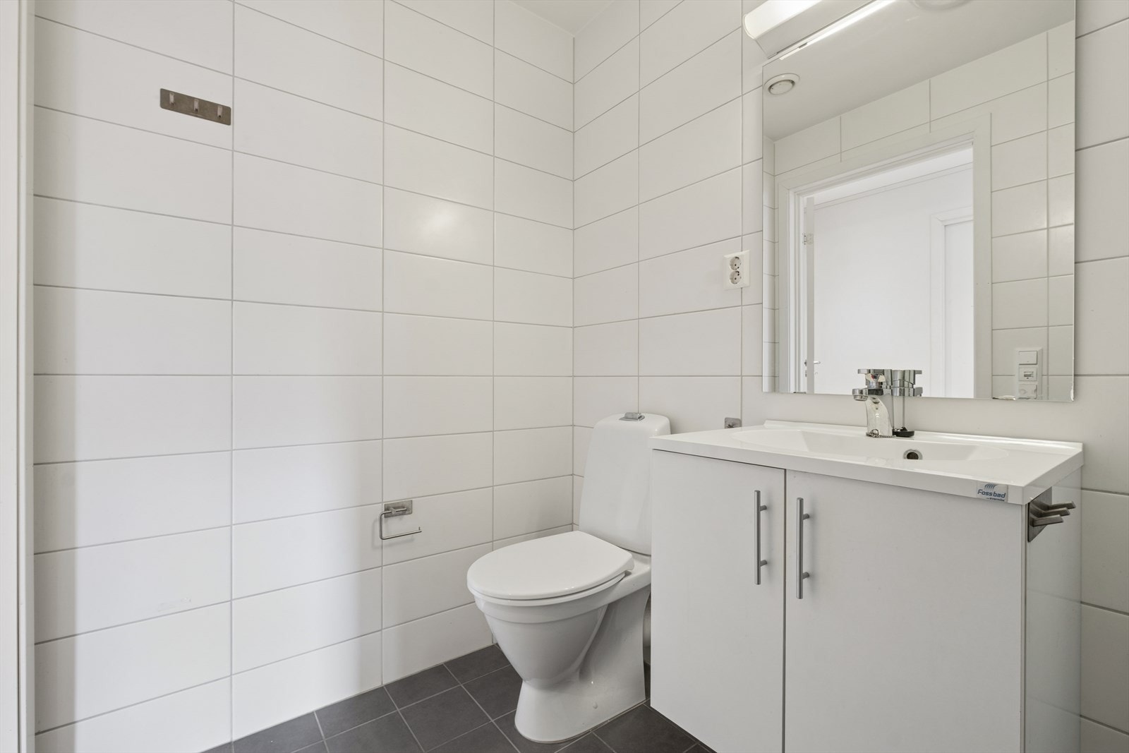 Badet er innredet med servantmøbel og gulvstående toalett. Den elektriske avtrekksviften ble skiftet i 2022. Galleribilde