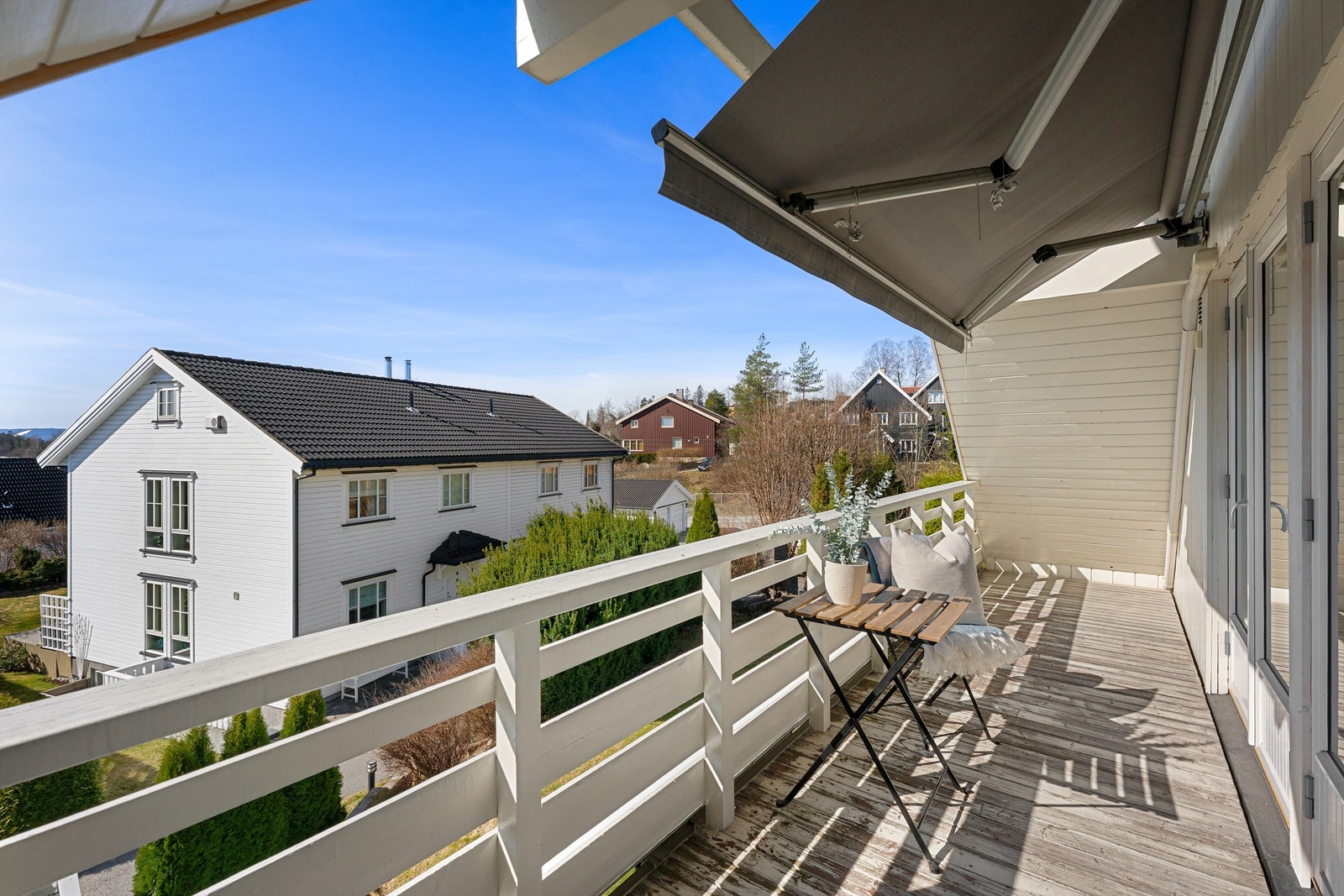 Balkongen er belagt med terrassebord og har plass til en liten sittegruppe. Galleribilde