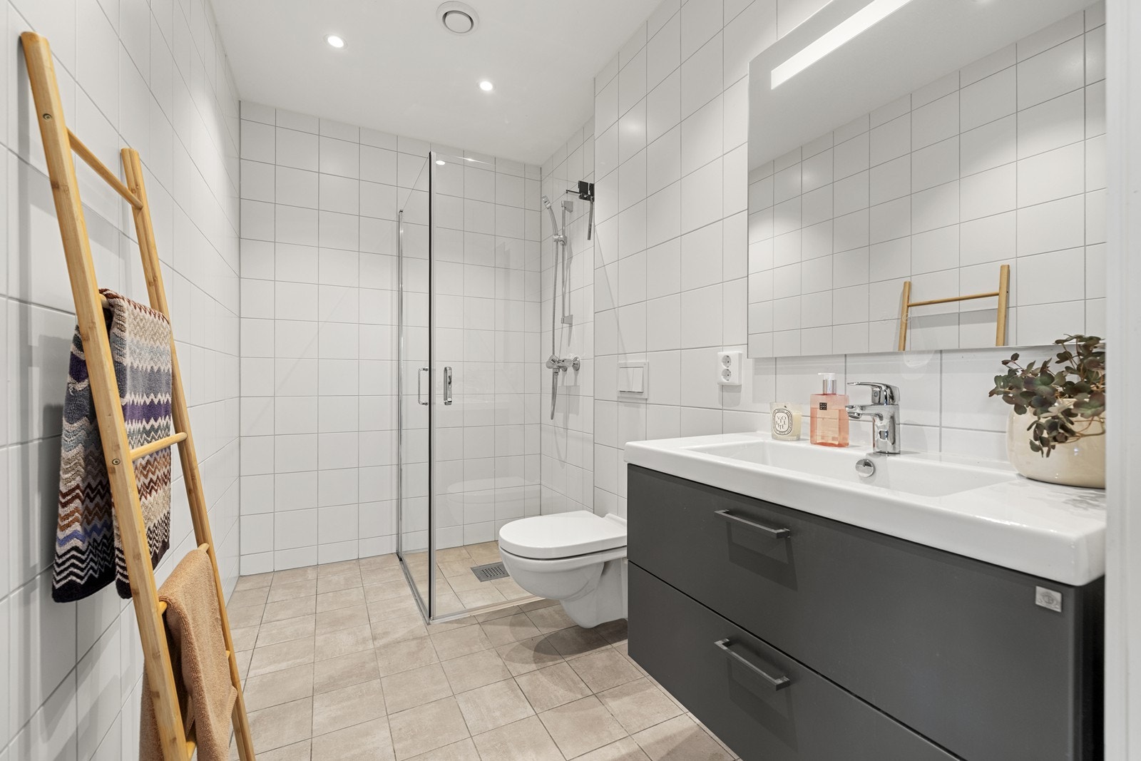 Badet i hybelen er helfliset og utstyrt med dusjvegger og vegghengt toalett. Galleribilde