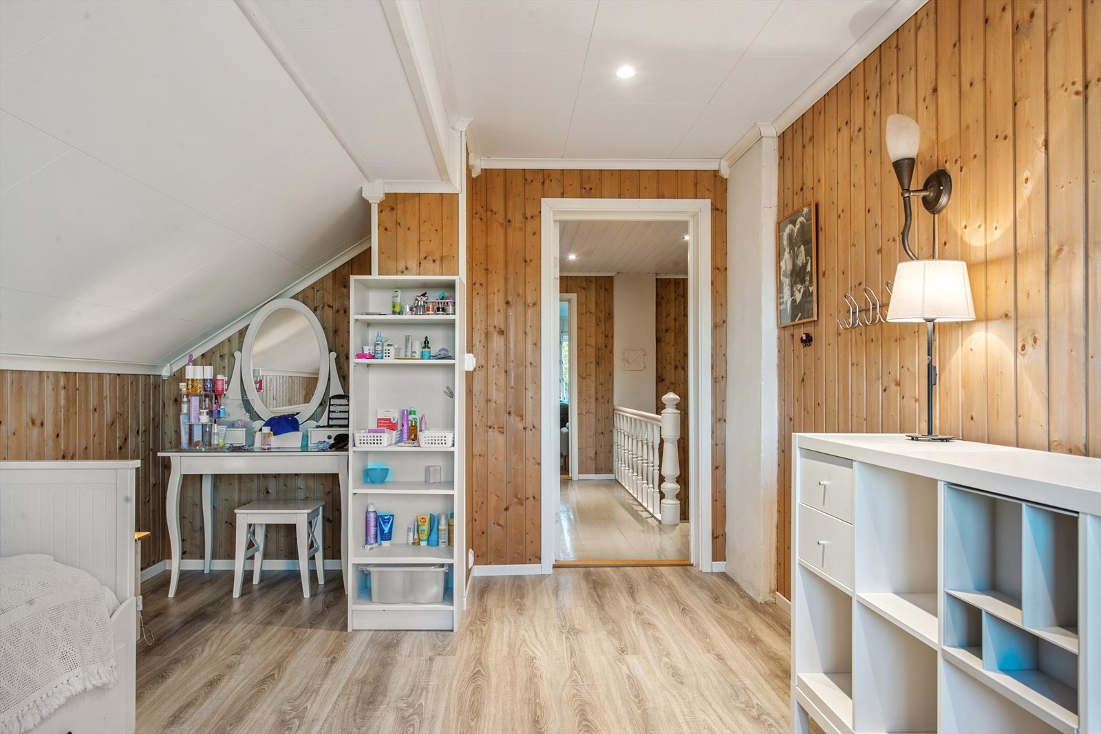 Et av soverommene i loftsetasjen, med sjarmerende skråtak og panelvegger. Galleribilde