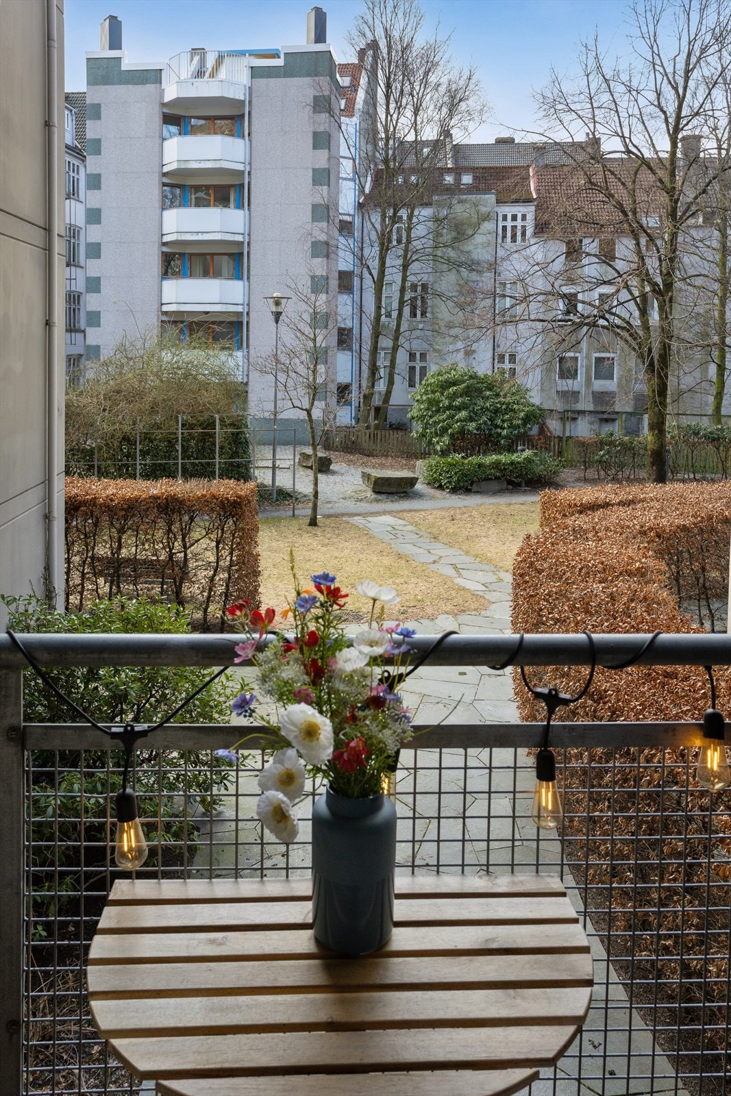 Fin beliggenhet mot pent opparbeidet bakgård med hage og beplantning Galleribilde