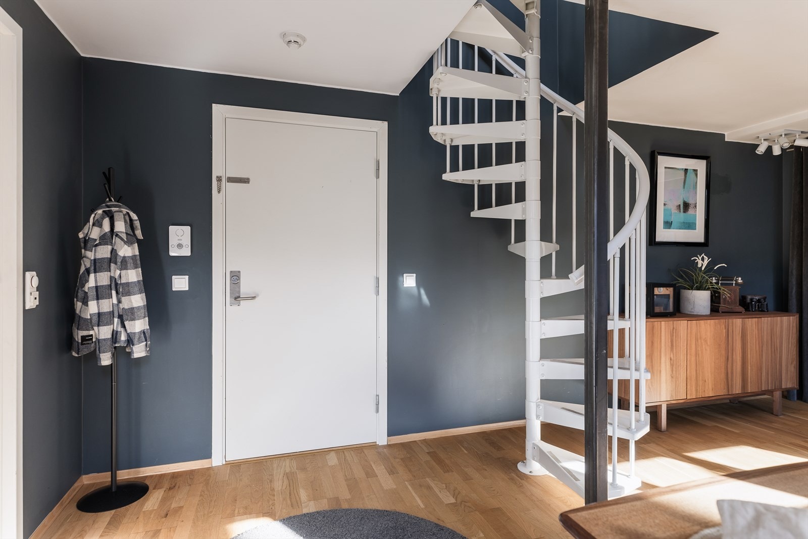 Innbydende entré med moderne fargevalg og en stilren kombinasjon av mørke vegger og lyse detaljer. Galleribilde