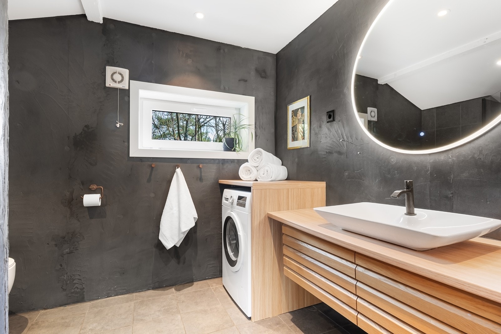 Badet har gjennomført materialbruk og et pent uttrykk. Innredningen består av servant og speil med integrert belysning, vegghengt toalett, samt dusjhjørne. Galleribilde