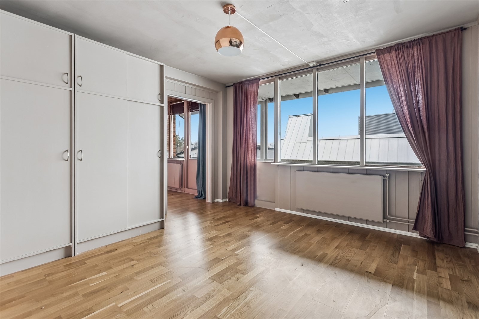 Romslig soverom med god skapplass og en finert skyvedør fra byggeåret som leder inn til stuen. Galleribilde