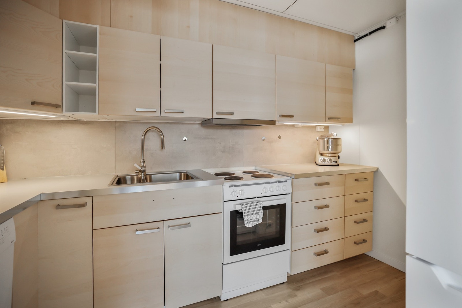 Kjøkkeninnredningen har glatte fronter og benkeplate med laminert overflate. Galleribilde