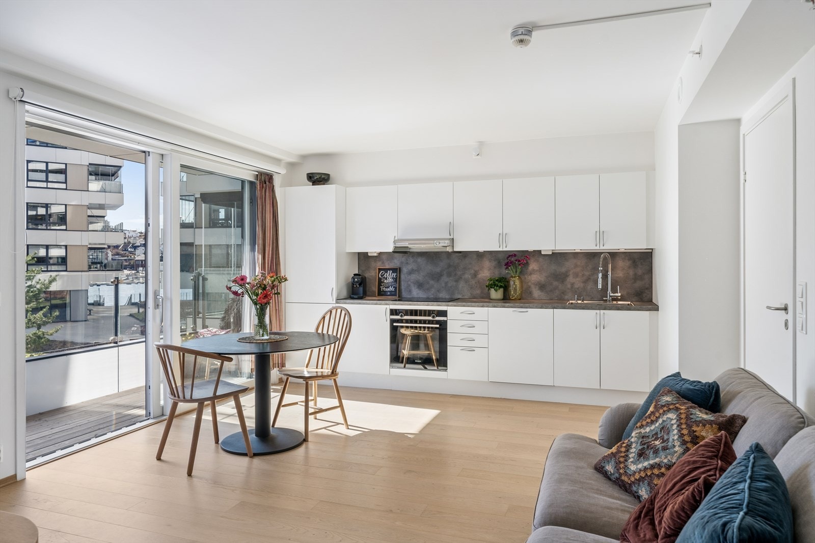 Ved spisestuen er det skyvedør i glass som tar deg ut til balkongen, som for øvrig også har rekkverk i glass Galleribilde