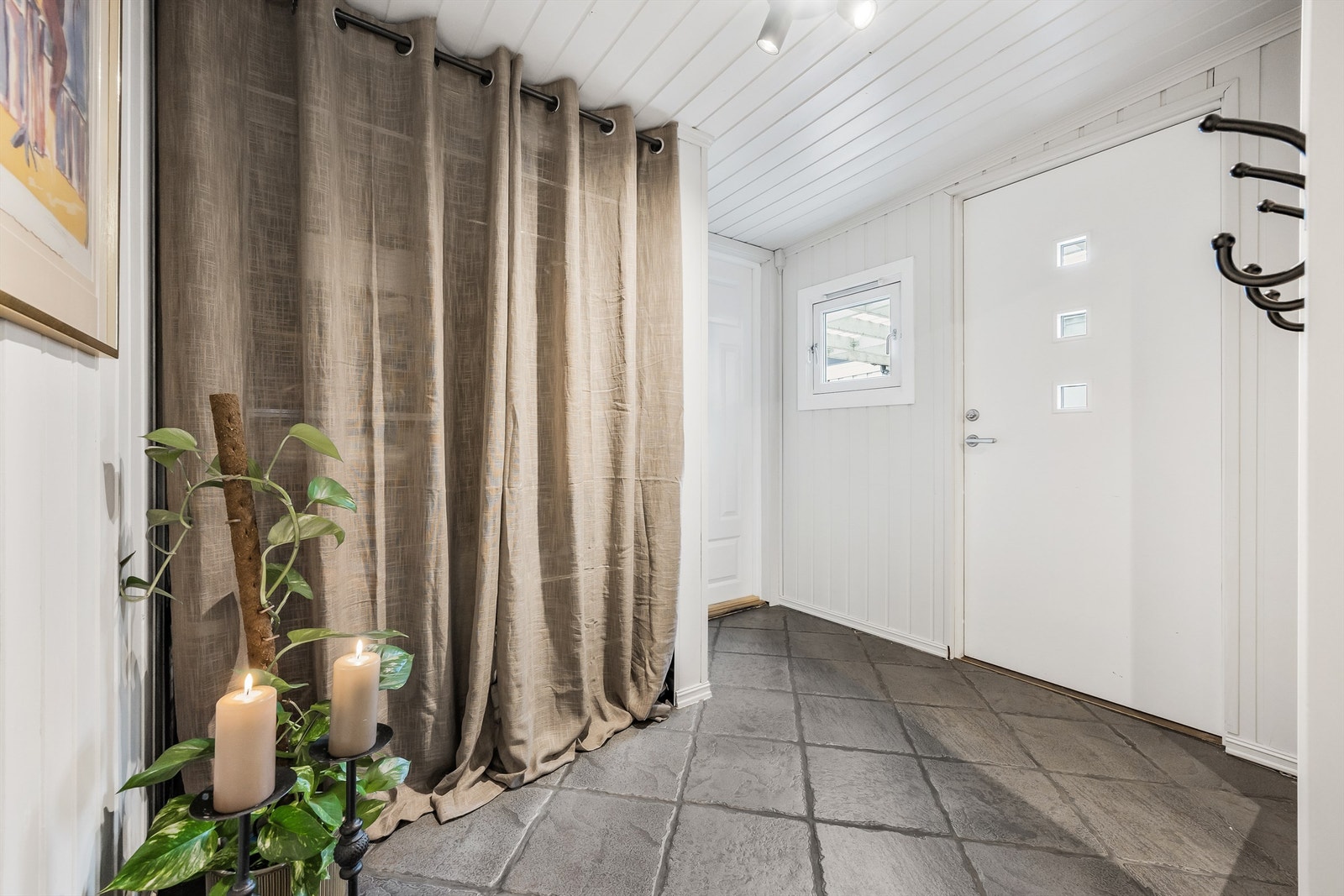 Ytterdøren med glassfelter er fra 2014 og slipper dagslys inn i gangen. Galleribilde