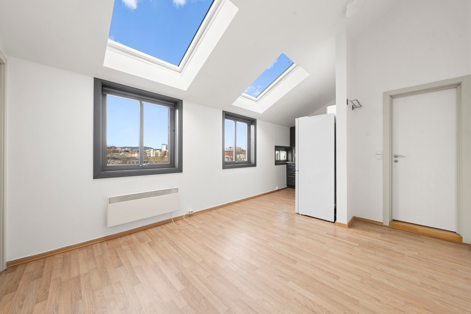 Leiligheten er malt i klassisk hvit og gulvet er belagt med 3-stavs laminat Galleribilde