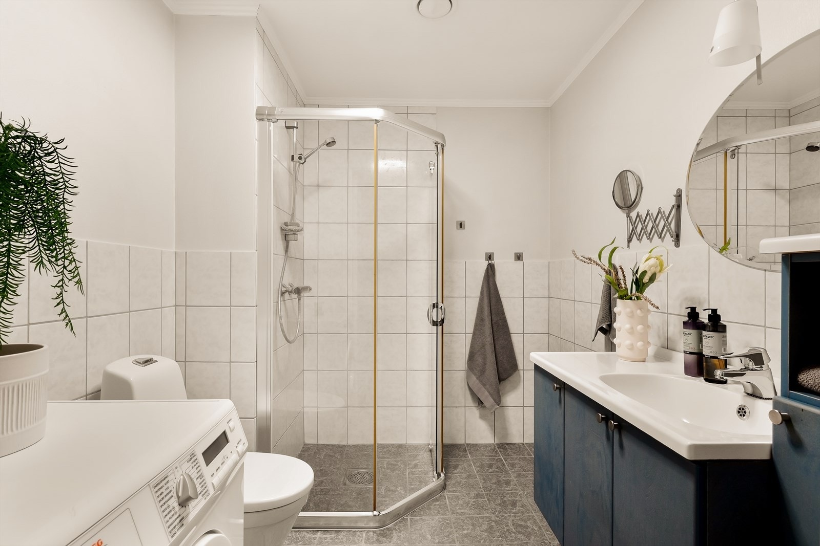 Badet/vaskerommet fremstår som praktisk og funksjonelt utformet med gode løsninger for en effektiv hverdag. Rommet har flislagte vegger i kombinasjon med malt strietapet, samt himling med malte plater som gir et lyst og ryddig uttrykk. Galleribilde