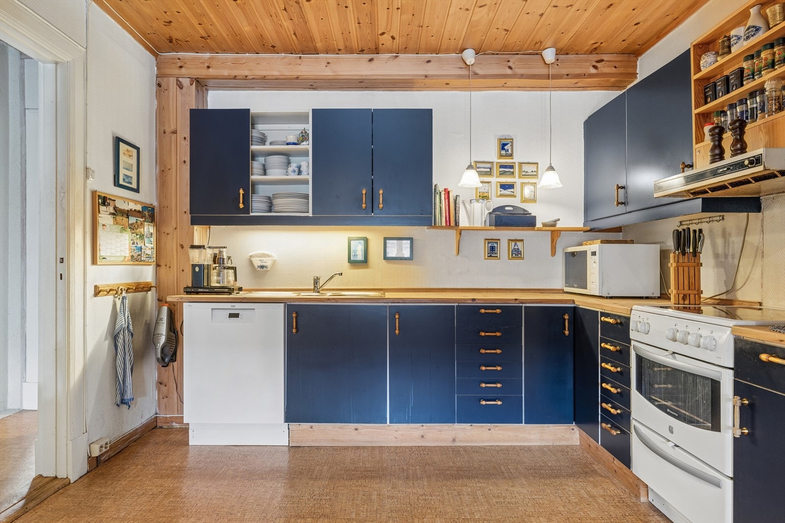 Kjøkkenet har en praktisk L-form med rikelig skap- og benkeplass. Galleribilde