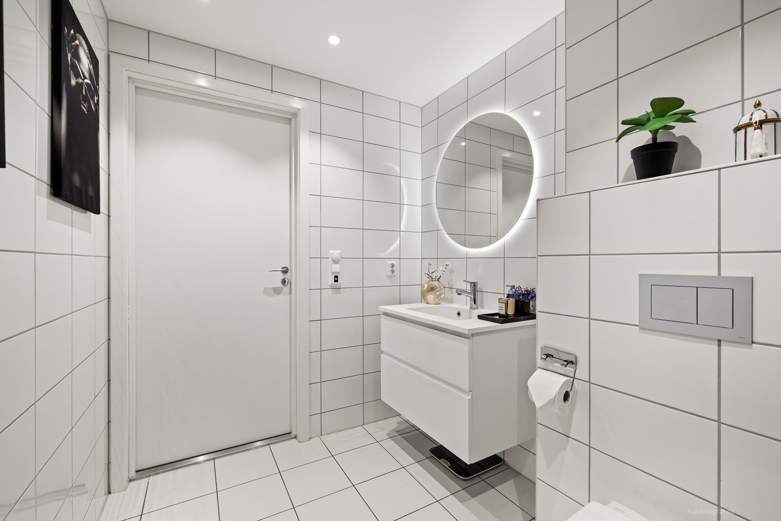 Badet er innredet med heldekkende nedfelt servant med rom for oppbevaring i underskap, speil med led lys, vegghengt toalett og dusjhjørne med innfellbare dusjvegger. Galleribilde
