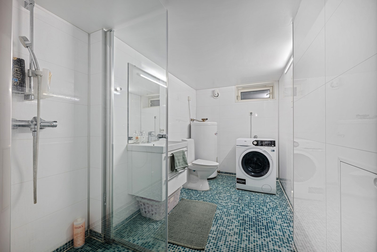 Her finner du badet i under etasjen. Praktisk bad med dusj, toalett, servant og opplegg for vaskemaskin. Galleribilde