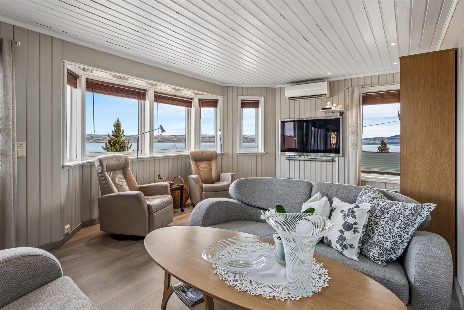 Store vindusflater i stuen gir rikelig med lys og rammer inn utsikten mot Mjøsa. Galleribilde