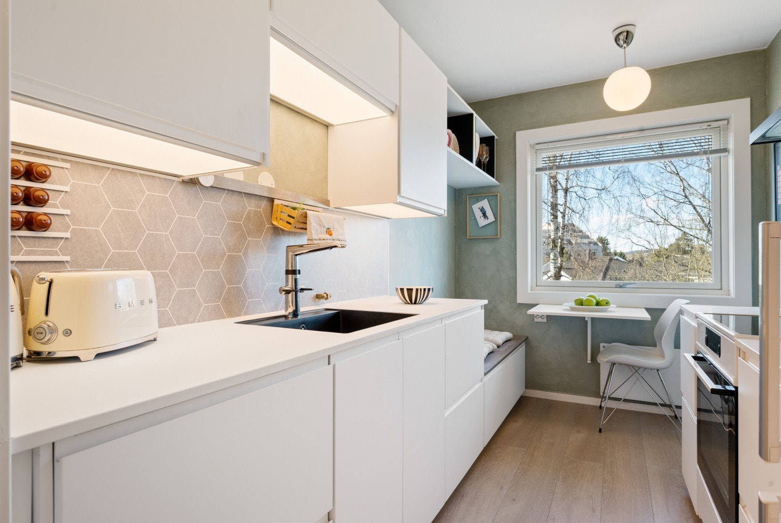 Kjøkkenet fra 2020 har en smart og arealeffektiv løsning, med integrert belysning og god benkeplass. Galleribilde