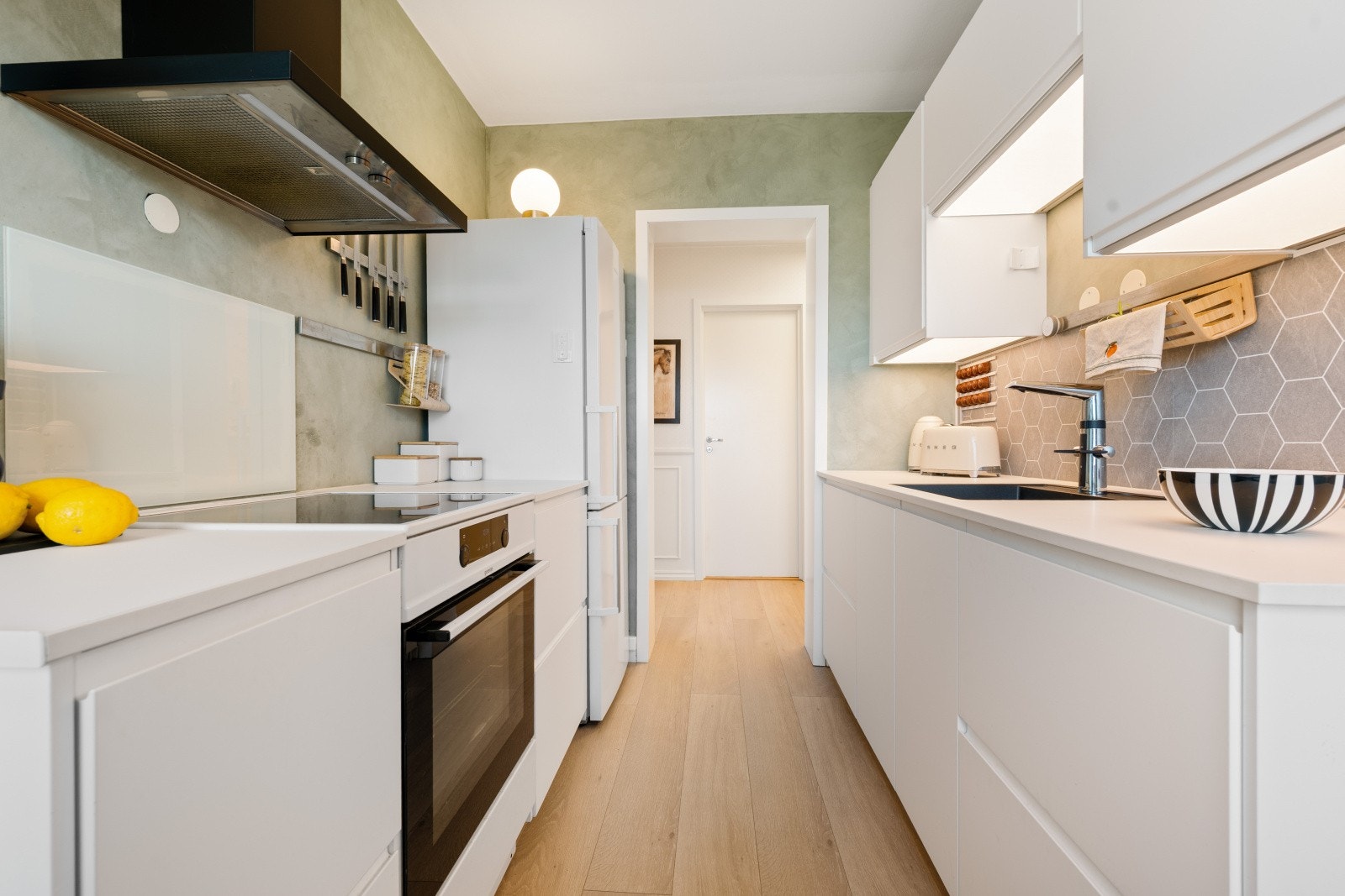 Kjøkkenet er utstyrt med komfyr, platetopp og ventilator med kullfilter. Varmtvannsberederen fra 2011 er plassert i underskapet. Galleribilde