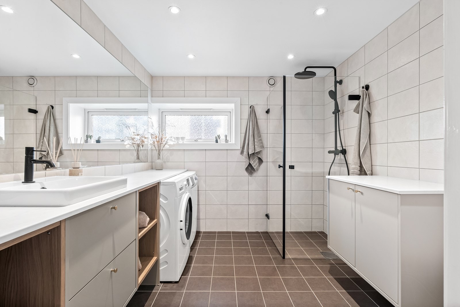 Romslig og moderne bad med vindu, arealeffektiv løsning og gode oppbevaringsmuligheter. Varmekabler i gulv, downlights i himling, samt opplegg/plass for vaskemaskin og tørketrommel Galleribilde