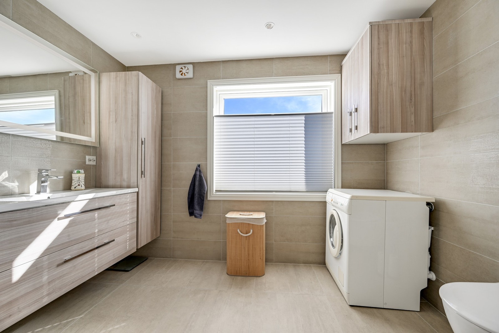 Det er godt med skapplass på badet og opplegg for vaskemaskin Galleribilde