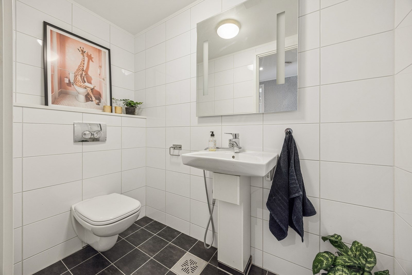 Praktisk, separat toalettrom i første etasje, også dette med flislagt gulv og vegger. Vegghengt toalett og vegghengt servant. Galleribilde