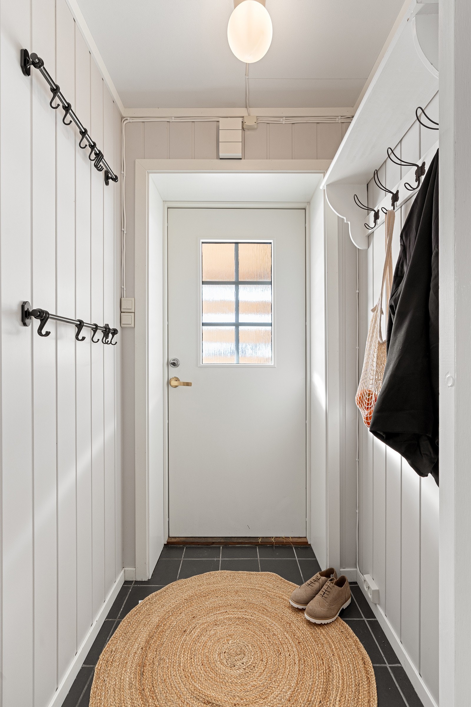 Entré med fliser på gulv.