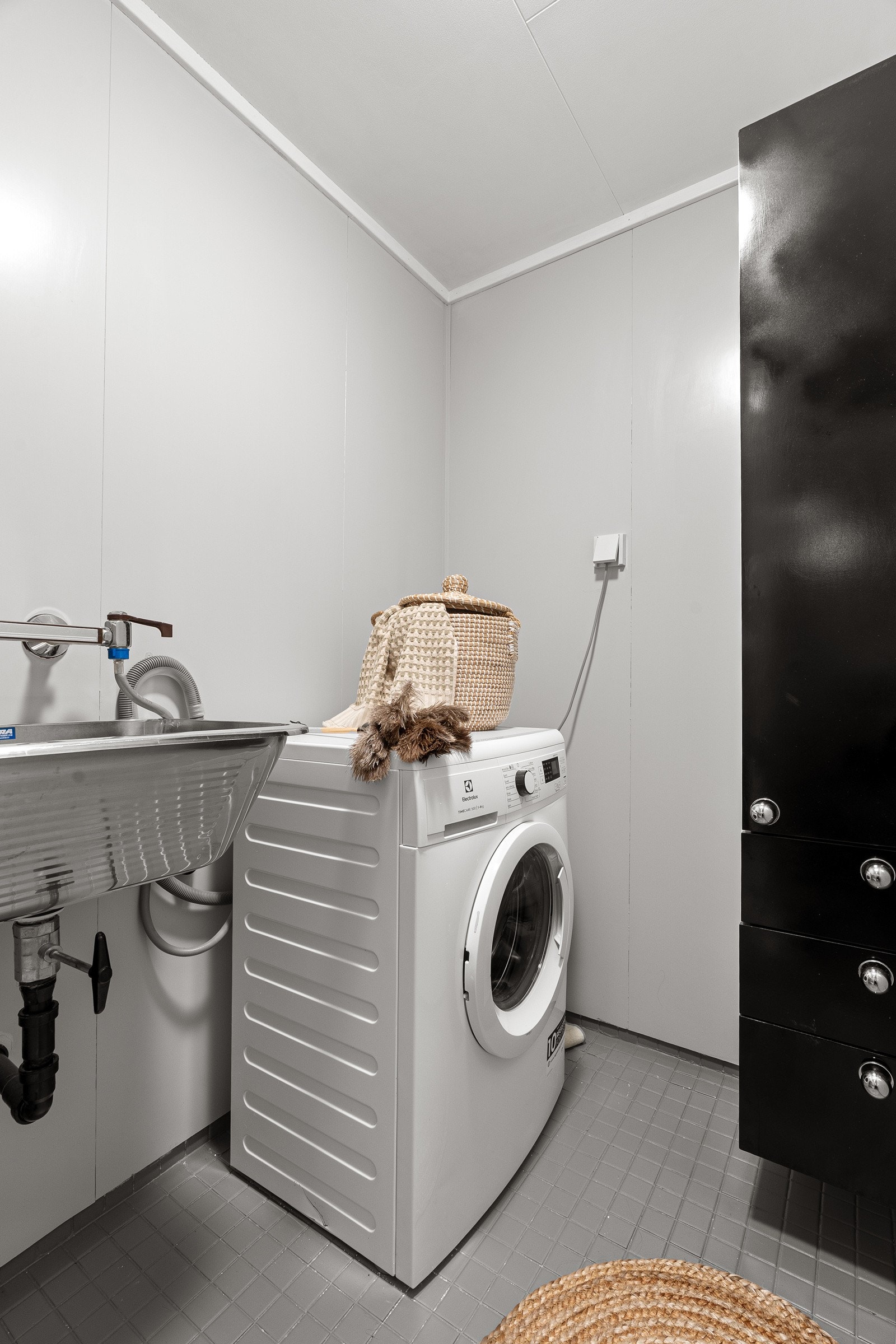 Videre har badet skyllekum, veggskap og opplegg for vaskemaskin