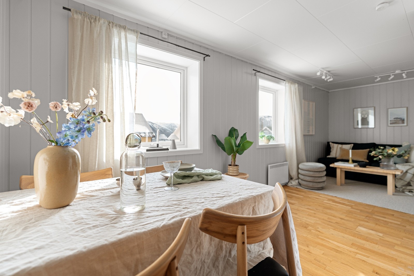 Lys og fin stue med malte veggoverflater og parkettgulv