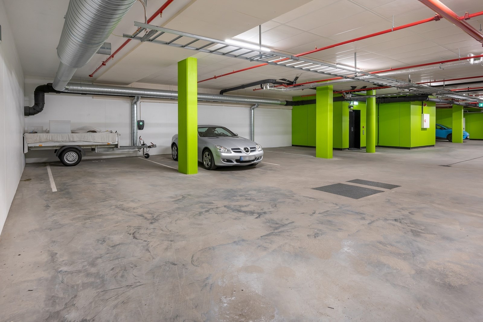 Parkeringsplassene er de to innerste. Den sorte døren er oppgangen til leiligheten. El.lader montert mellom plassene Galleribilde