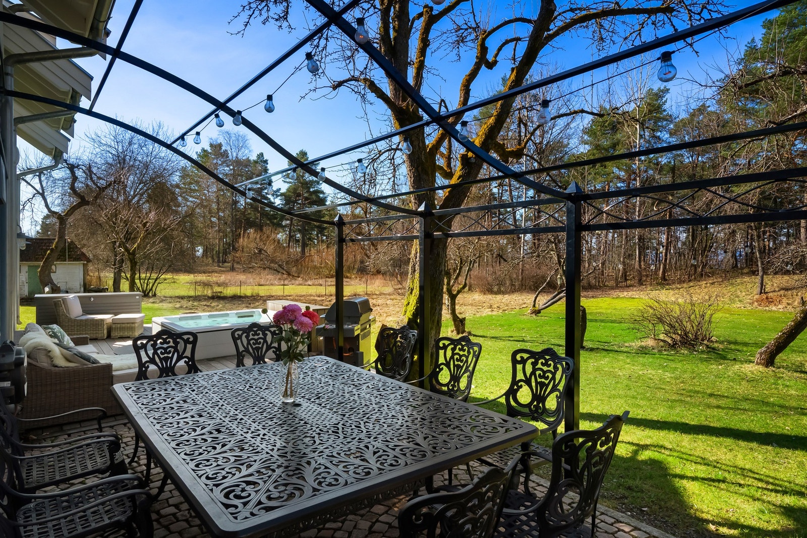 Steinbelagt uteplass med pergola og terrasse med jacuzzi Galleribilde