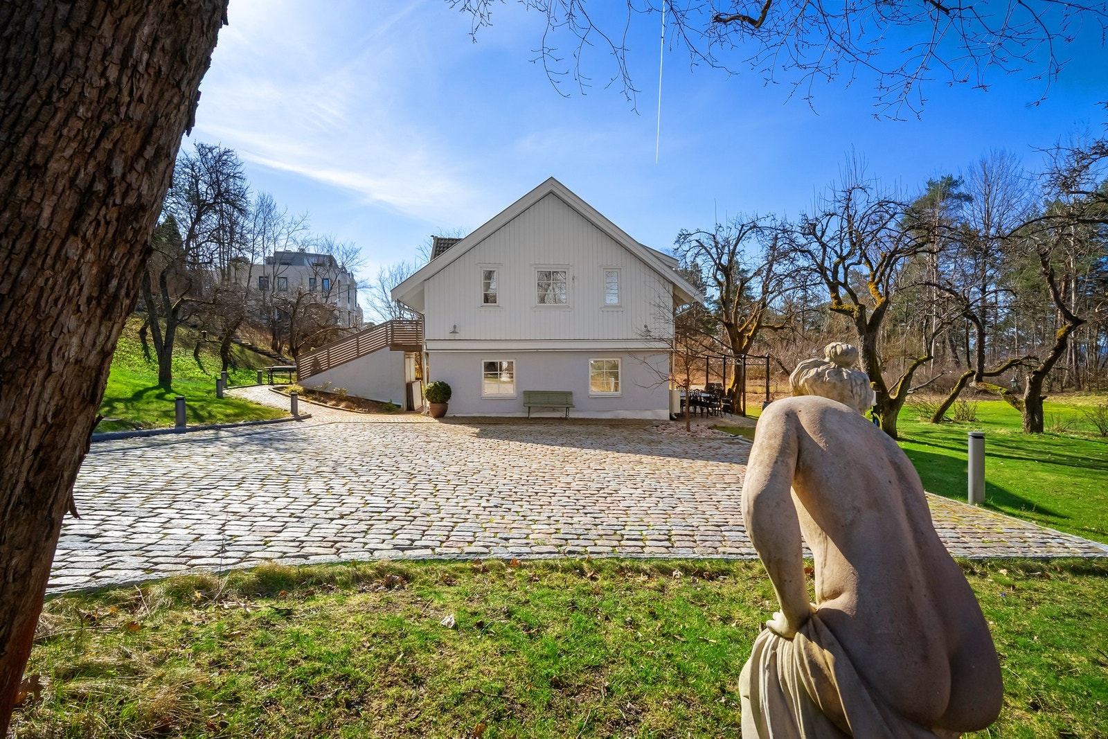 Stor gårdsplass med plass til flere biler. Det er montert ladestolpe for el-bil Galleribilde