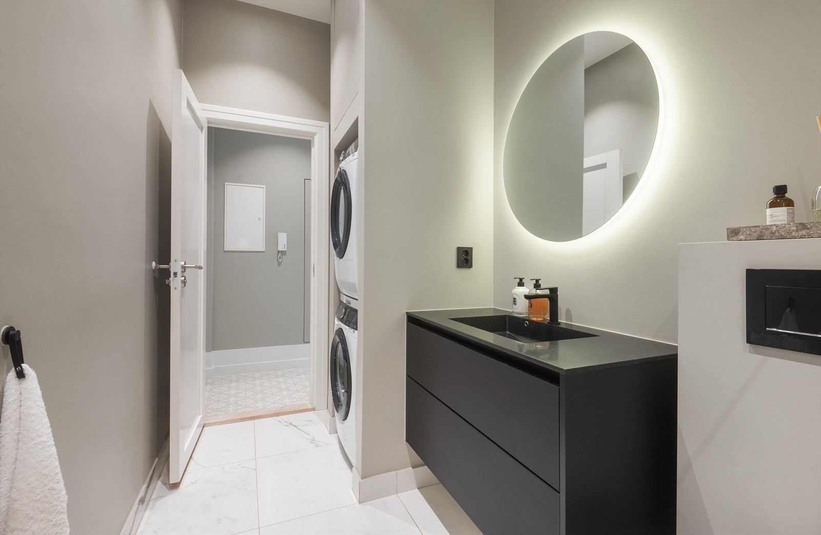 Spesialbestilt baderomsinnredning i matt sort fra HTH Marbrè Bagno med trento vask i galaxy sort og Foss Moon speil med backlight. Galleribilde