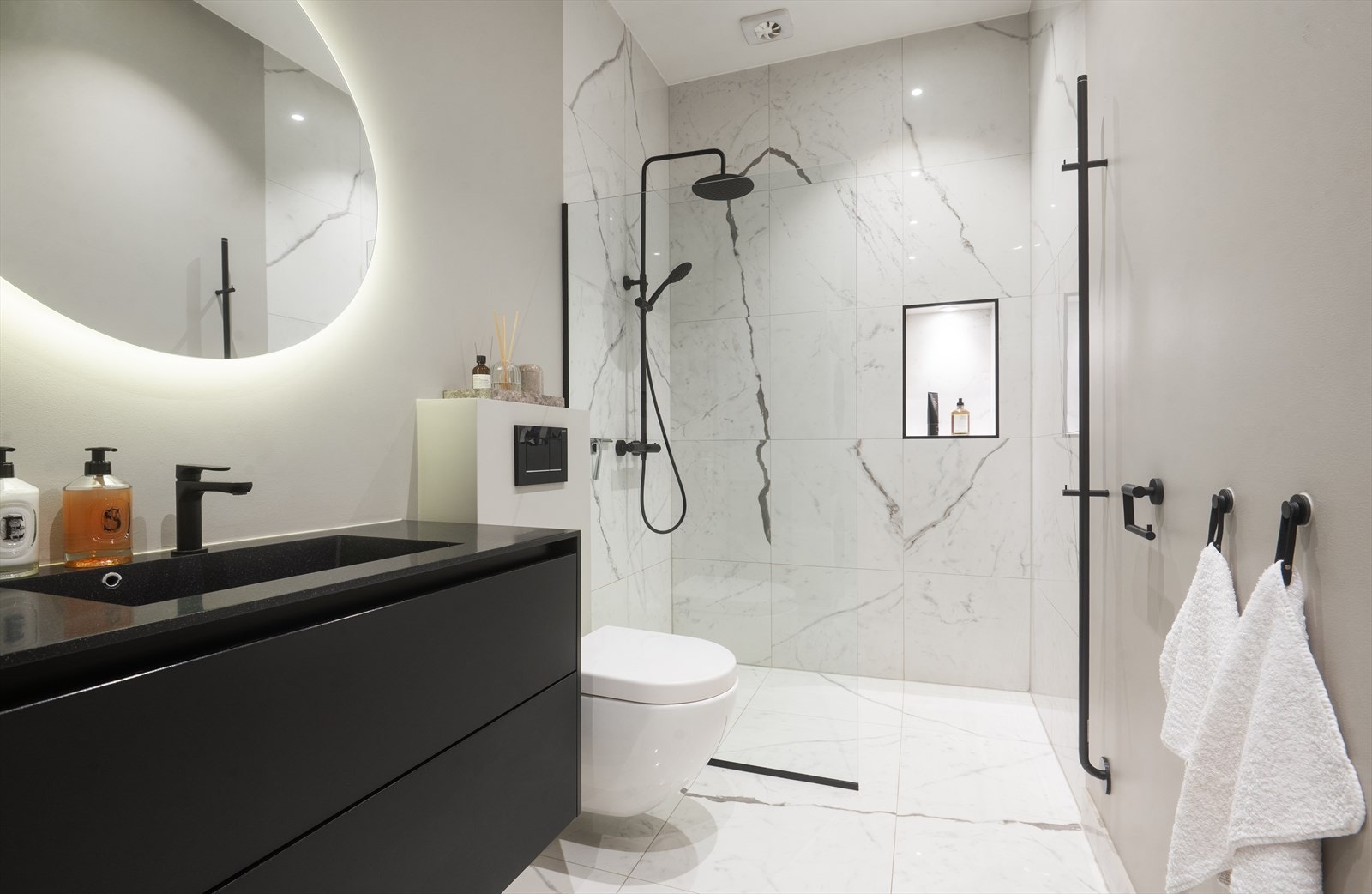 Lekkert bad fra 2019 med italienske designfliser fra LEA Cheramiche i 60x60, matt sort håndkletørker fra INR og regnfallsdusj og servant blandebatteri i matt sort. Galleribilde