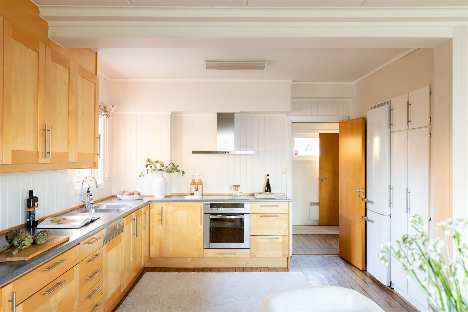 Kjøkkeninnredningen har profilerte fronter og en slitesterk laminat benkeplate med nedfelt vask- og skyllekum. Galleribilde