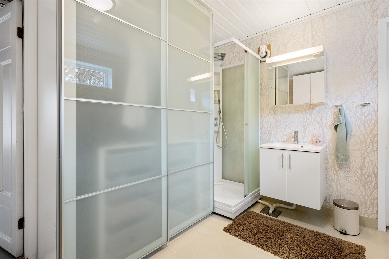 Stort bad/vaskerom på 10m² med dusjkabinett, servant og opplegg for vaskemaskin. Galleribilde