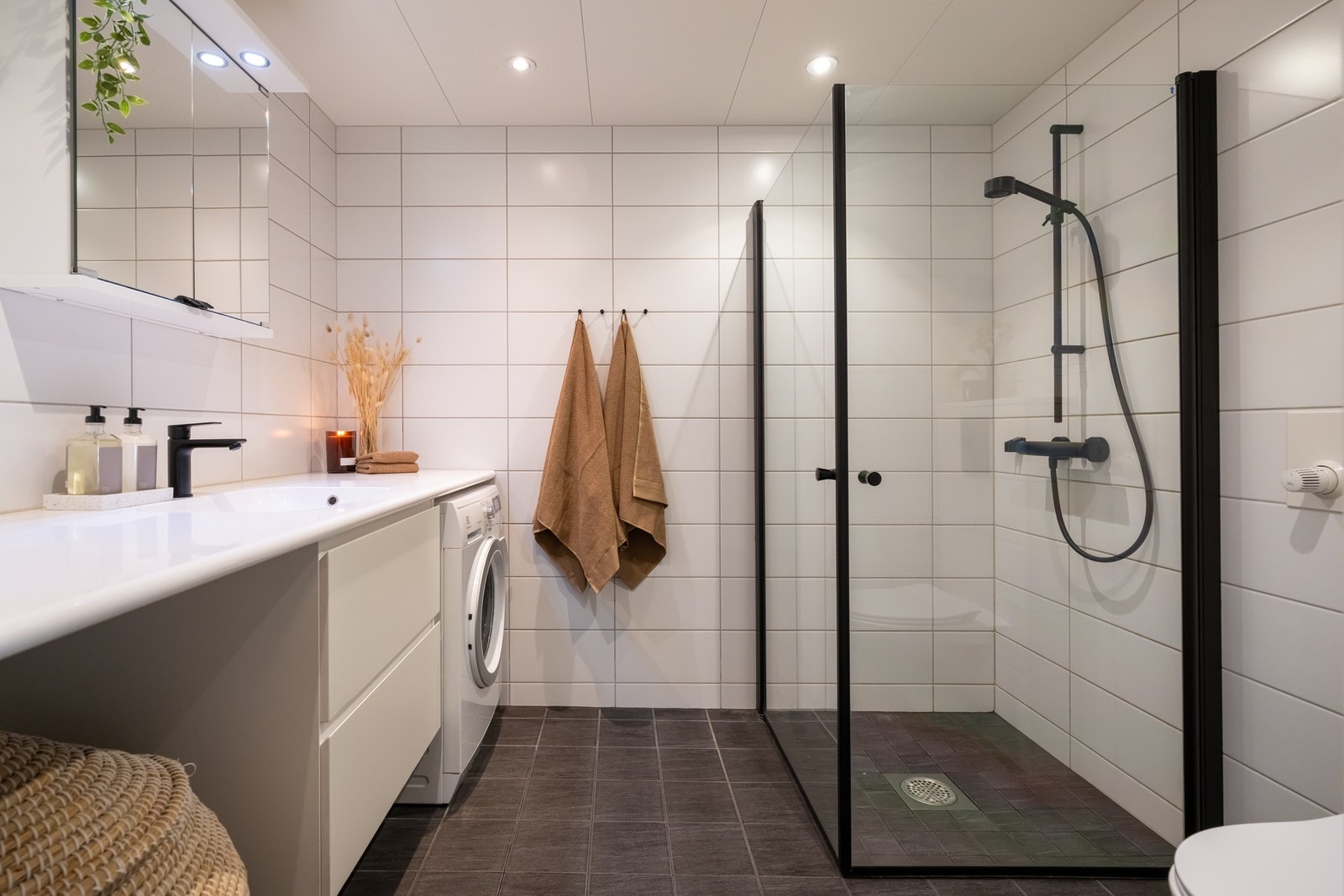Badet er pent flislagt og har varme i gulv samt downlights i himling. Det er opplegg for vaskemaskin plassert under benk. Galleribilde