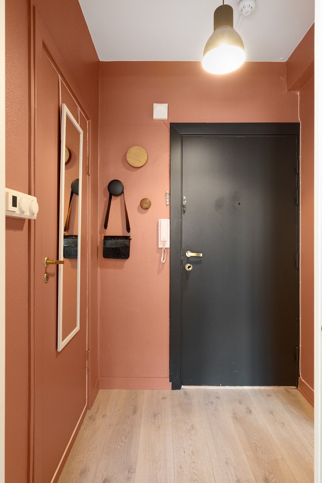 Velkommen inn! Leiligheten har en innbydende entré som skaper et umiddelbart godt førsteinntrykk. Her kan du enkelt henge i fra deg yttertøy på knaggrekke. Galleribilde