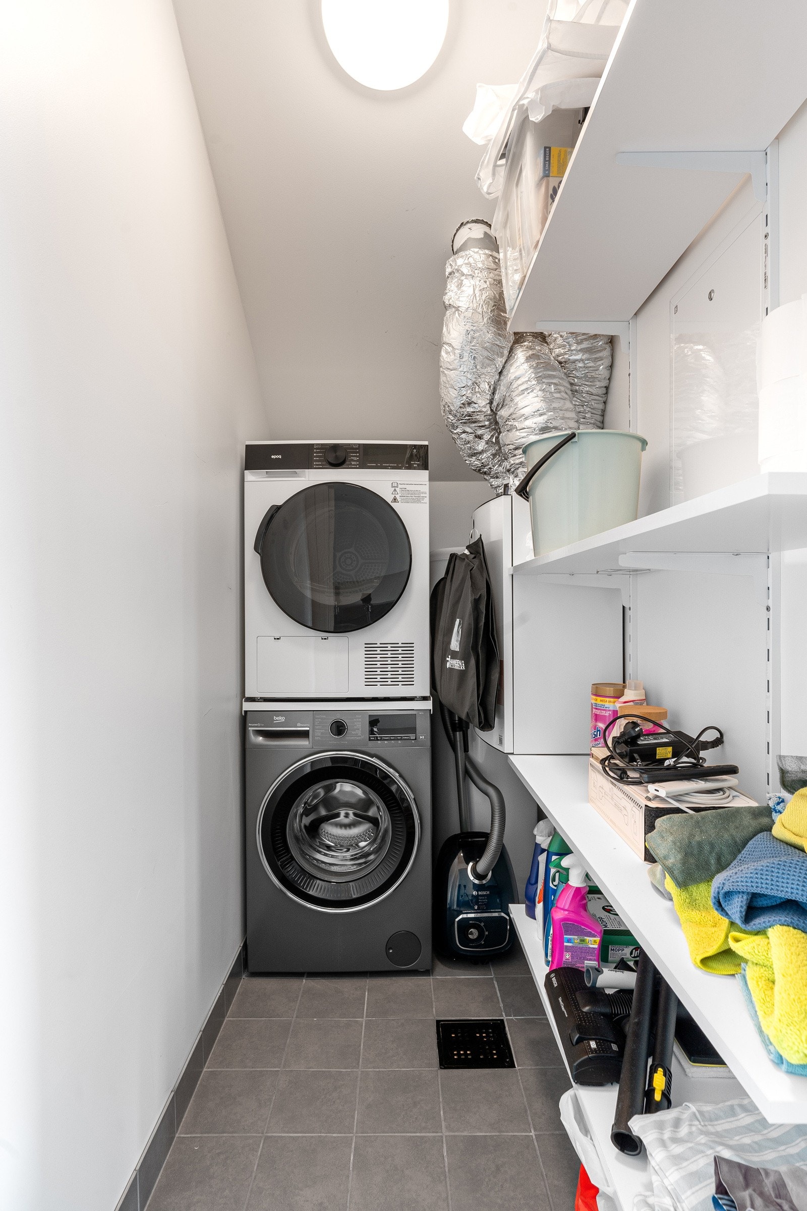 Vaskerom/teknisk rom med praktiske hylleløsninger.