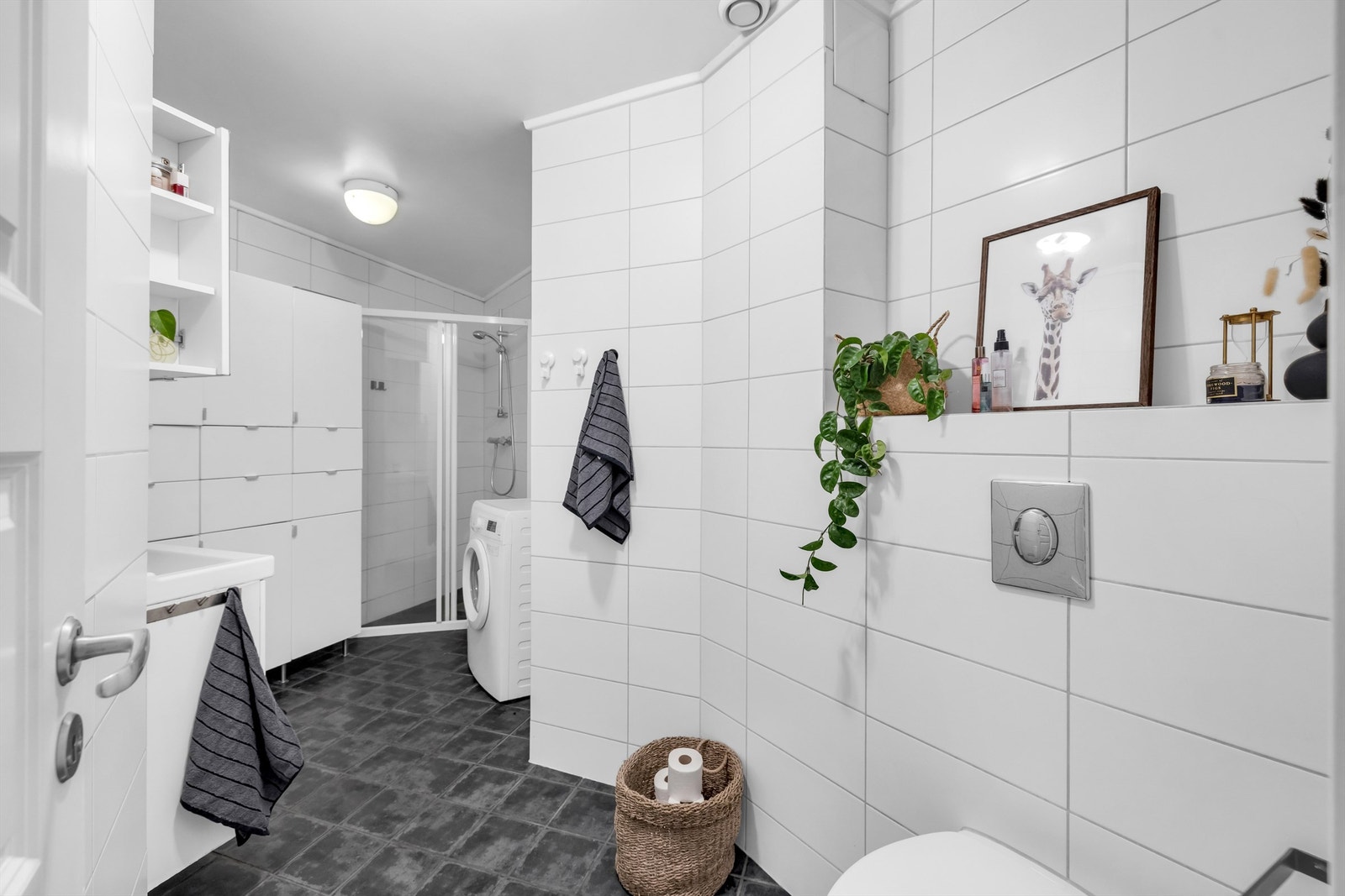 Flislagt bad med varmekabler i gulvet og lyse fliser på veggene som gir et lyst og rent uttrykk. Galleribilde