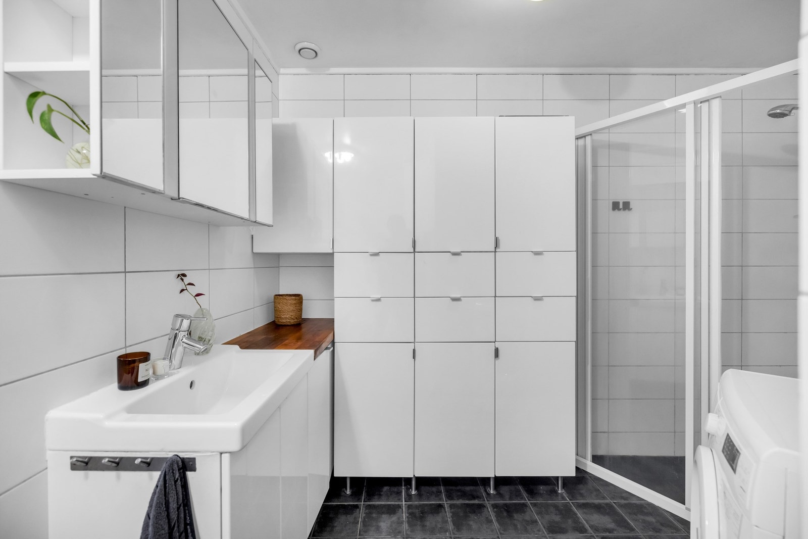 Badet fremstår som funksjonelt med gode oppbevaringsløsninger, blant annet skapinnredning som gir rikelig med lagringsplass, samt en elegant hylleløsning over toalettet som er integrert i veggen og gir et pent og moderne uttrykk. Galleribilde