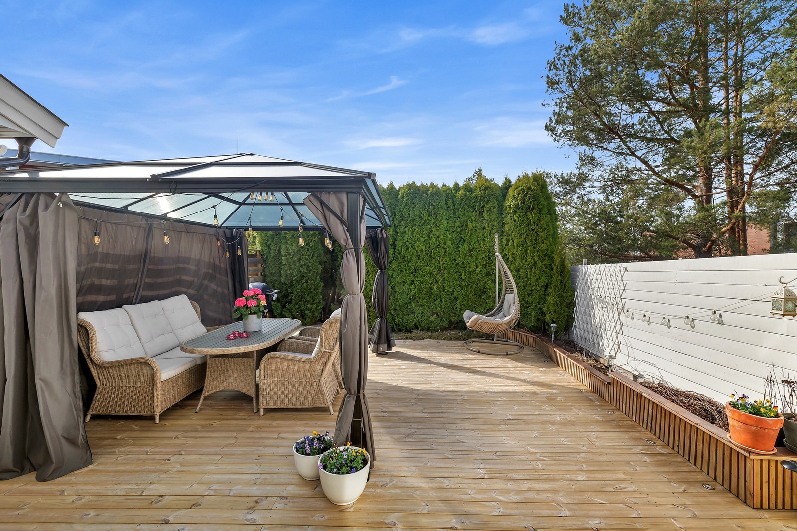 Terrassen er 42 kvm og er pent opparbeidet med tujahekk og blomsterkasse Galleribilde