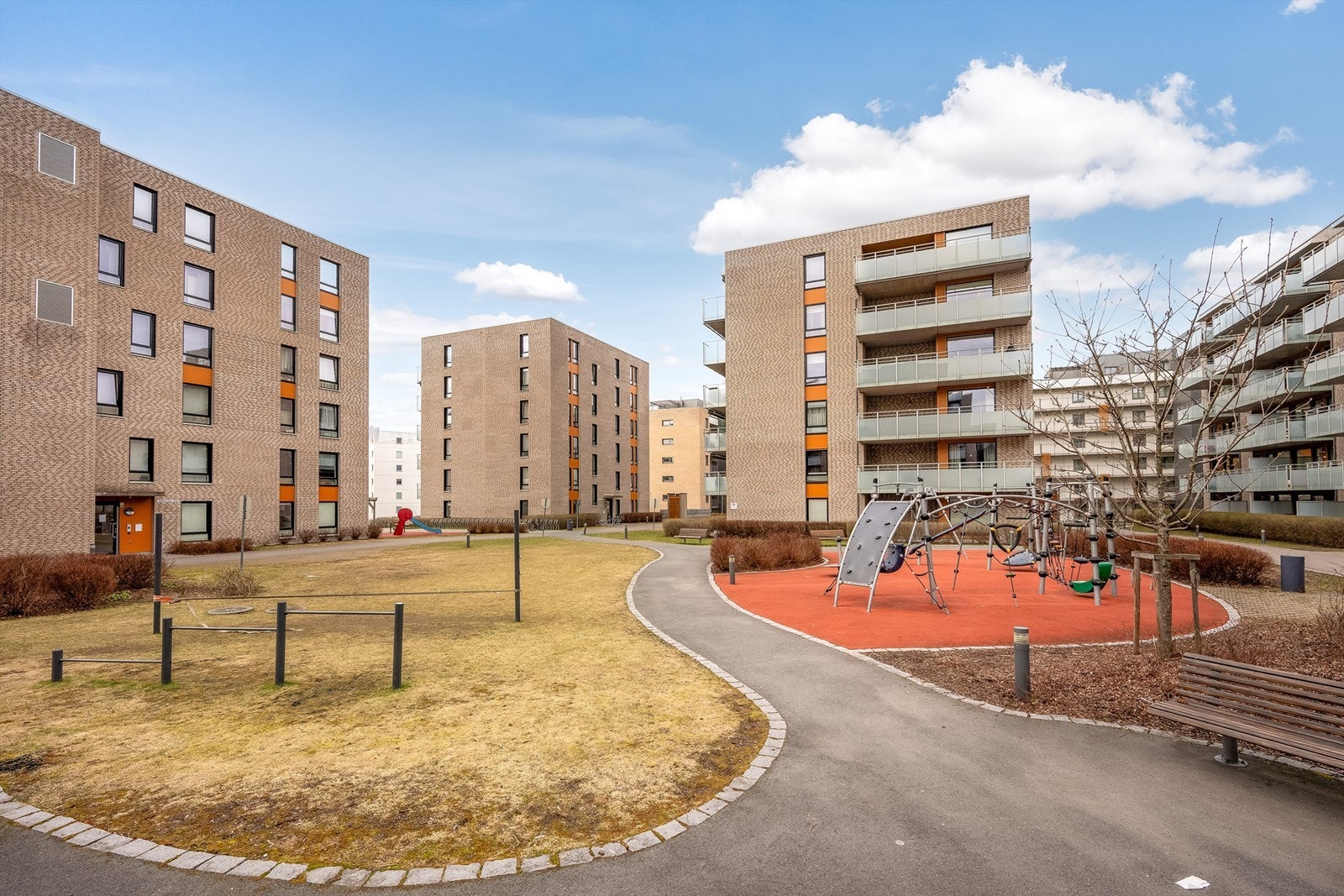 Flotte fellesområder med gressplen, sittebenker og lekeplass for de minste Galleribilde