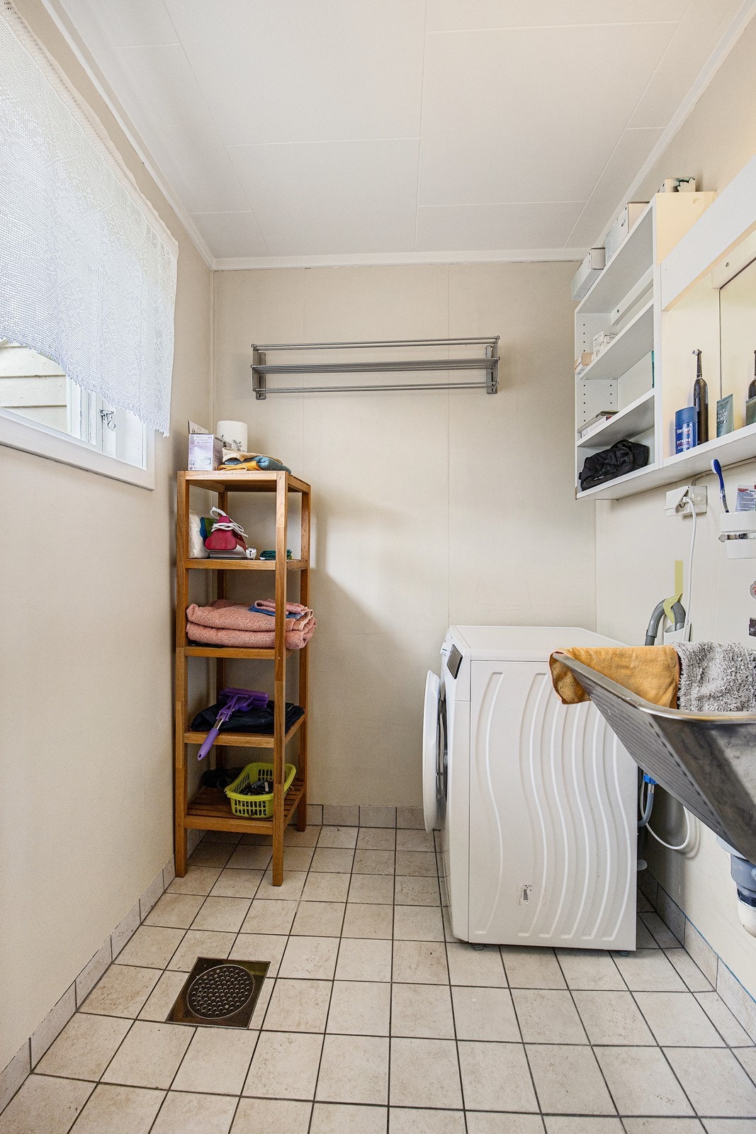 På vaskerommet er det utslagsvask, åpne hyller og flislagt gulv med varme. Galleribilde