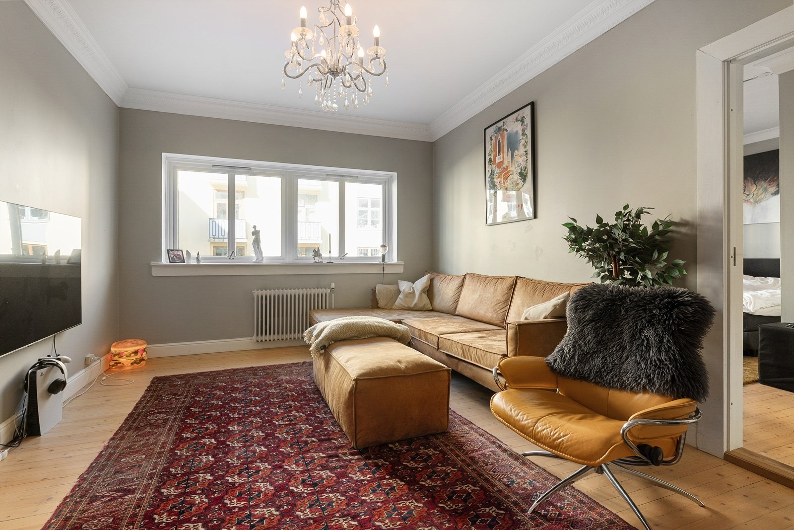 Lys stue med plass til sofagruppe, sofabord og underholdningsavdeling. Galleribilde