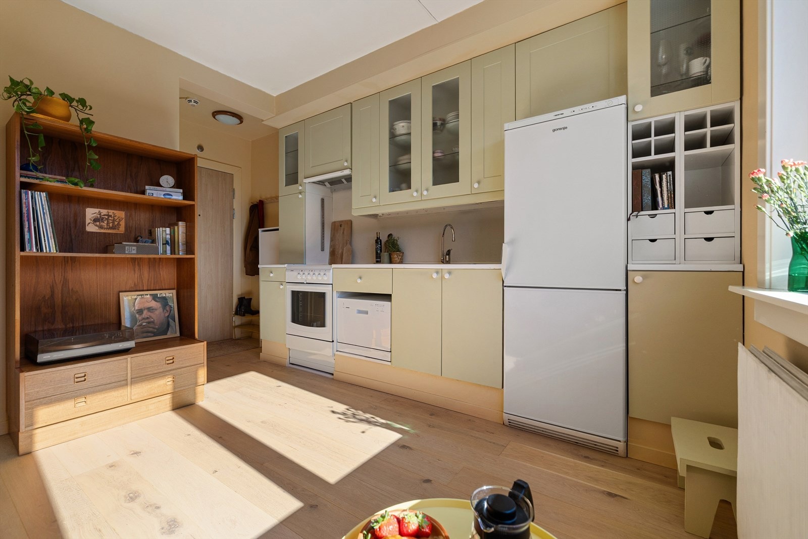 Kjøkkeninnredning fra ukjent årstall med slette og profilerte fronter. Benkeplater av laminat med nedfelt oppvaskkum. Det er benkeskapsbelysning og stikkontakt under overskap. Galleribilde