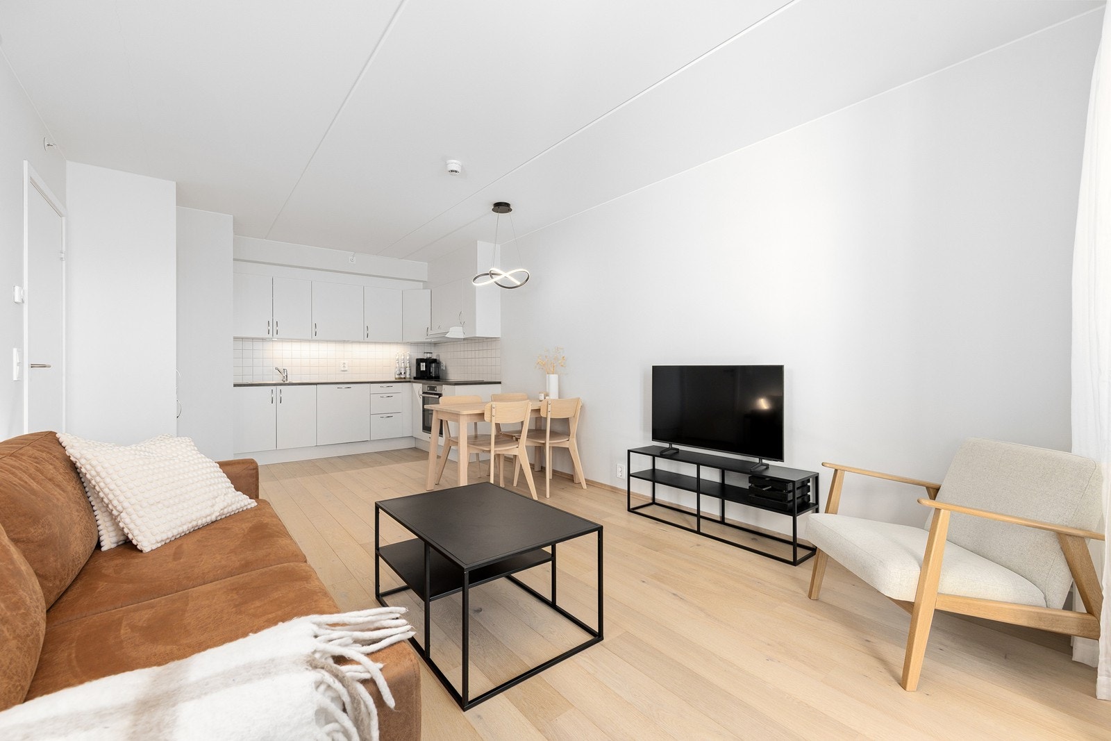 Planløsningen har en funksjonell utforming som gir plass til både sofa og en liten spisegruppe. Galleribilde