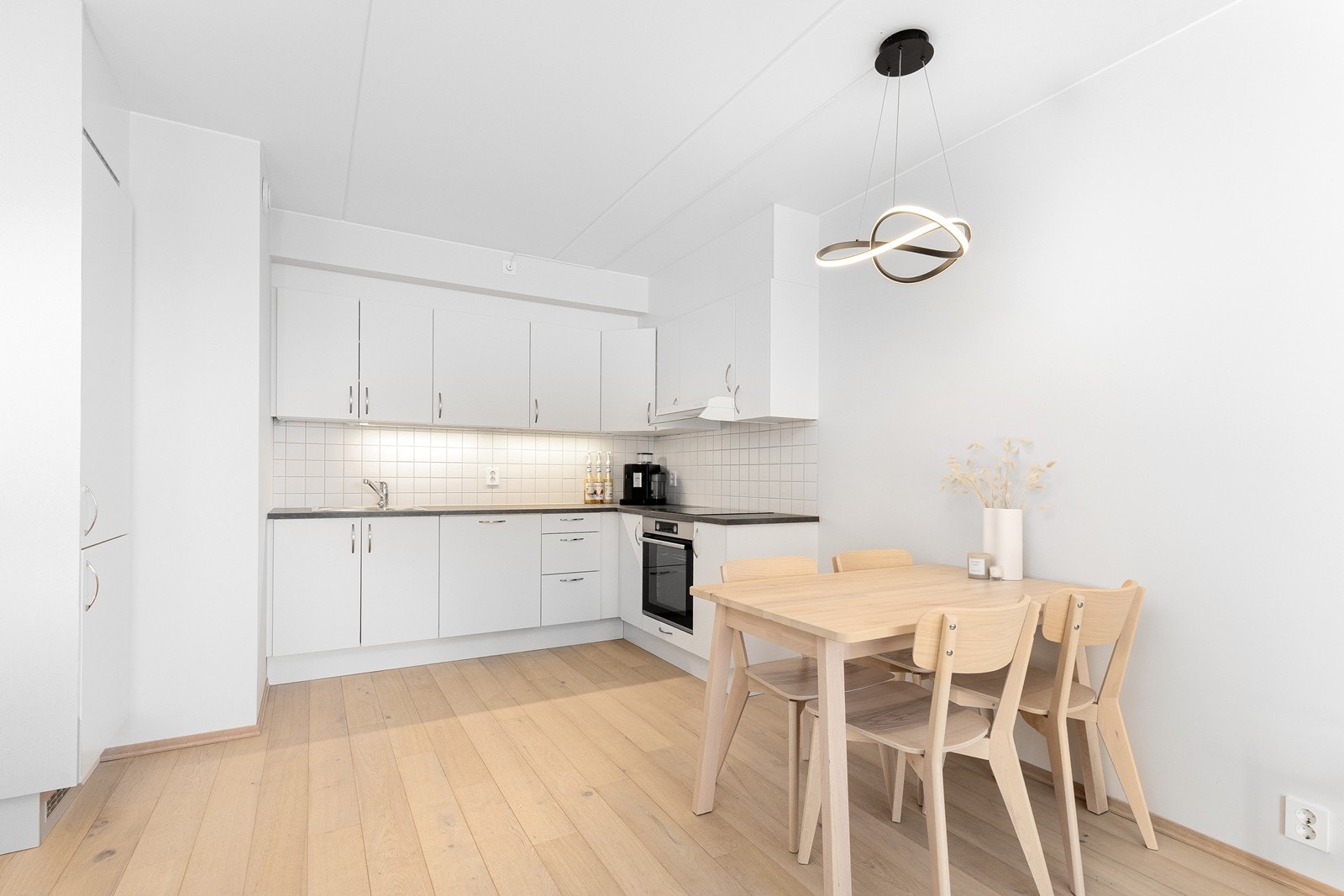 Kjøkkenet har en tidløs innredning med glatte fronter, benkeplate av laminat og integrerte hvitevarer. Galleribilde