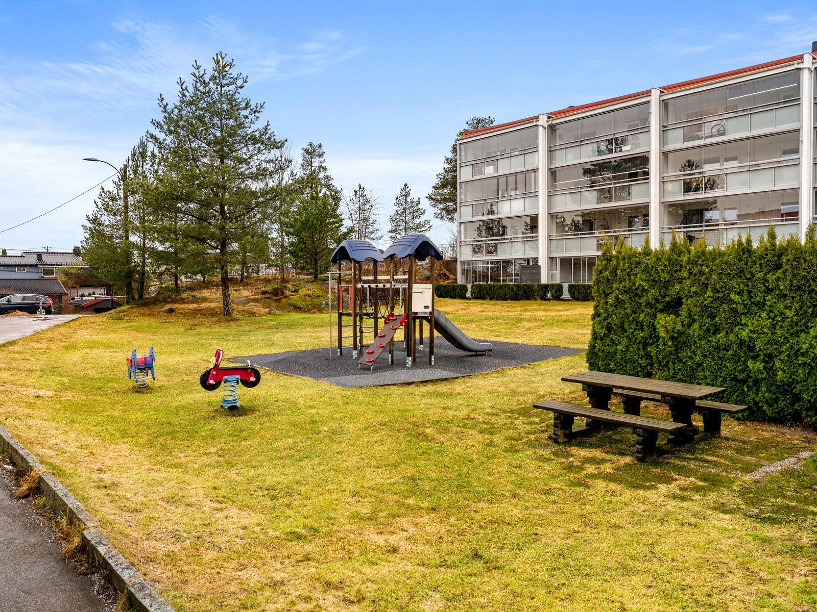 Fellesområdet er pent opparbeidet med gress, busker og lekeplass for de minste. Galleribilde